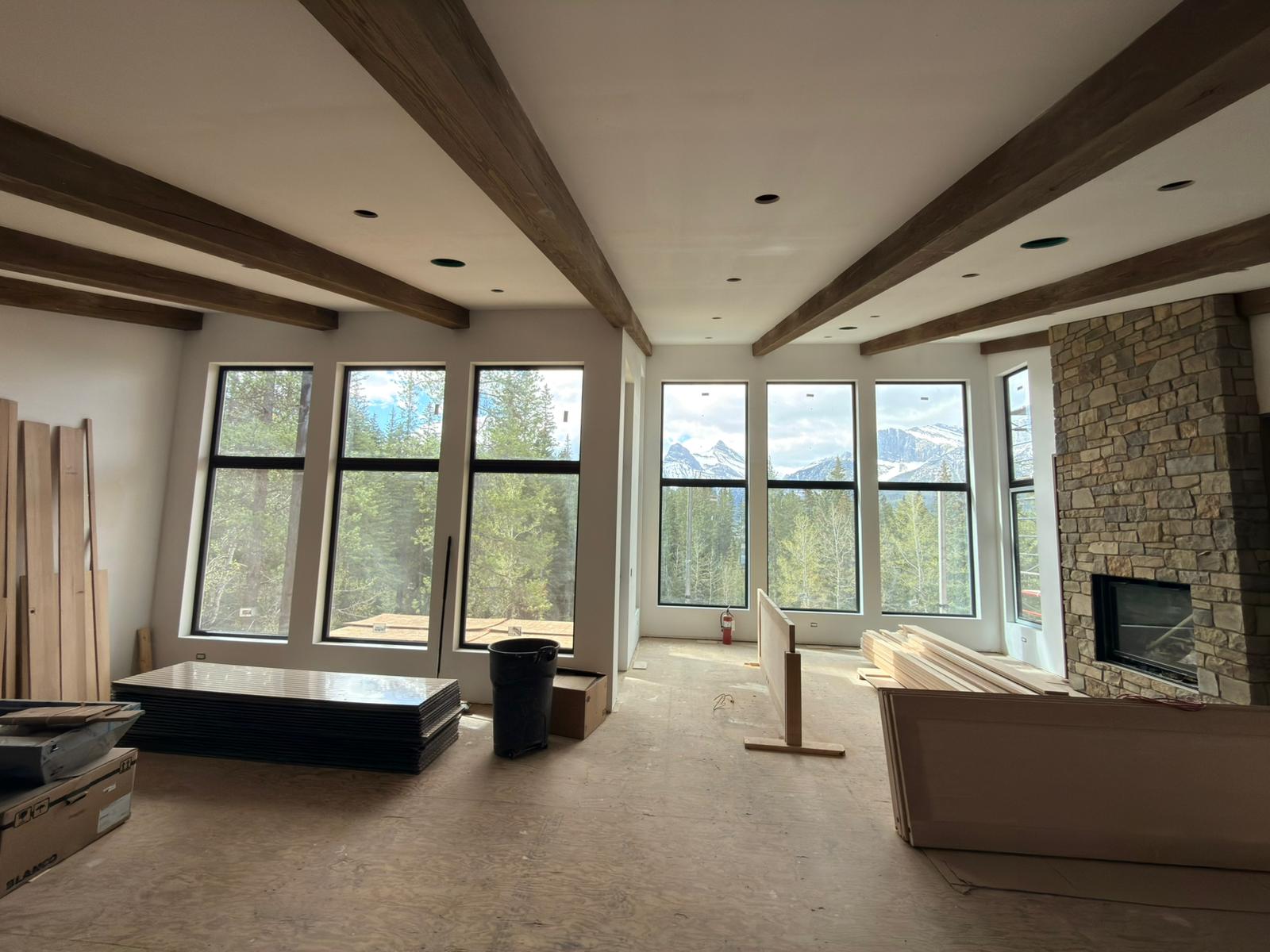 Same great room different angle showing window wall depth and fireplace stone